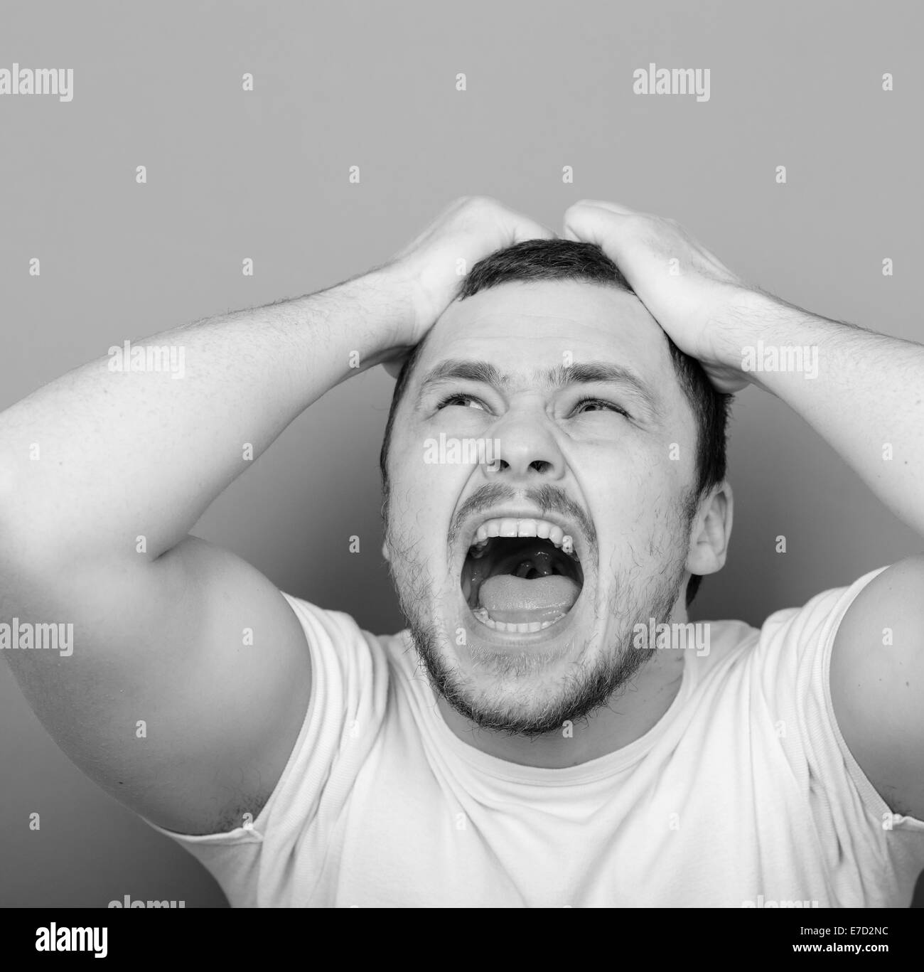 Portrait of angry man screaming and pulling hair - Monocrome or black and white portrait Stock Photo