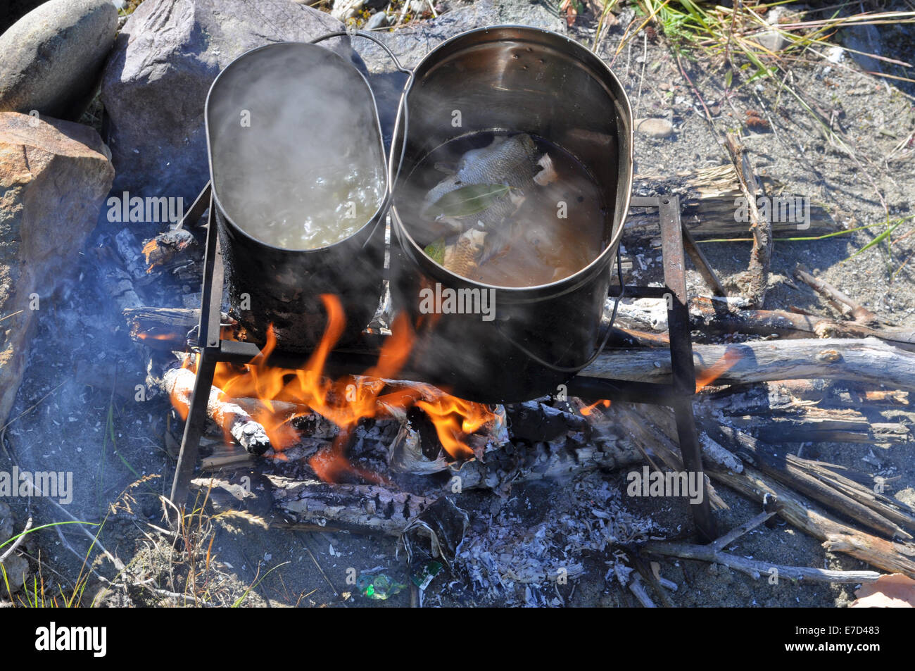 https://c8.alamy.com/comp/E7D483/cooking-fish-on-the-fire-tourist-fire-trivet-and-two-pot-that-cooked-E7D483.jpg