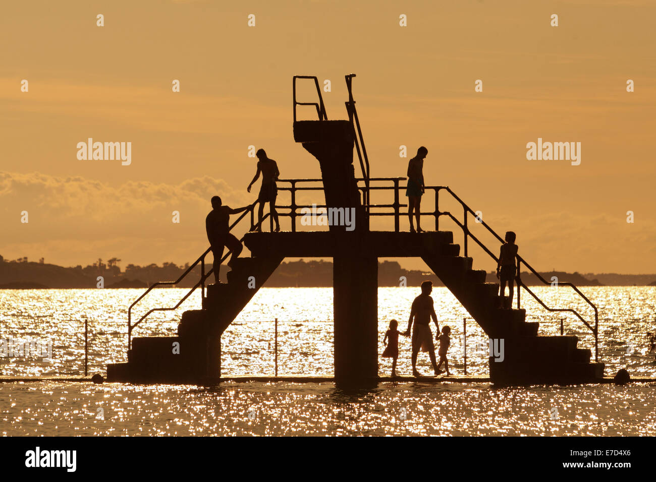 Youths diving and jumping from a sea bathing area diving platform, St Malo, Britanny, France Stock Photo