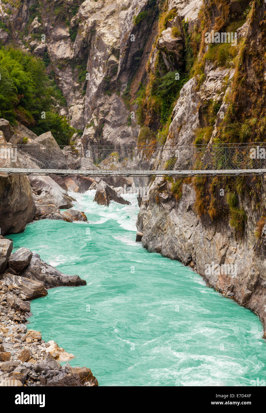 Hanging suspension bridge in Himalaya mountains, Nepal. Stock Photo