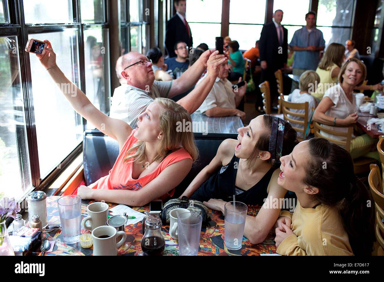 Patrons pose for a selfie as President Barack Obama greets patrons at the Magnolia Cafe July 10, 2014 in Austin, Texas. Stock Photo
