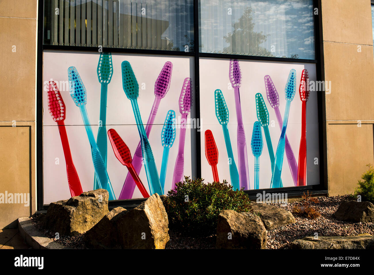 Large illustration of coloured tooth brushes on exterior of dentistry pracrice, Derry, Londonderry, Northern Ireland. Stock Photo