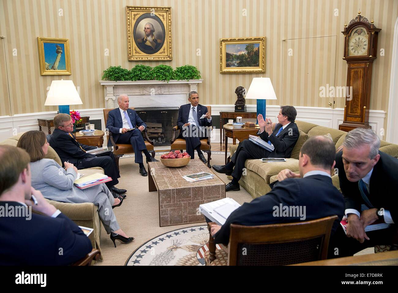 US President Barack Obama and Vice President Joe Biden receive the Presidential Daily Briefing as Chief of Staff Denis McDonough, right, confers with Ben Rhodes, Deputy National Security Advisor for Strategic Communications, in the Oval Office of the White House July 18, 2014 in Washington, DC. Stock Photo