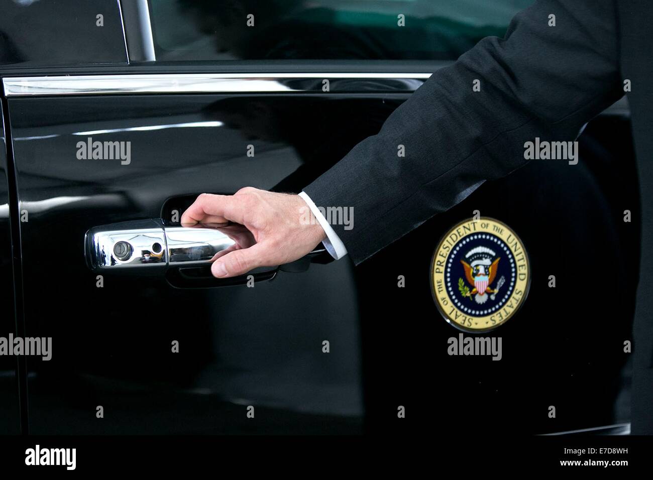 A US Secret Service agent waits to open the motorcade door as President Barack Obama arrives at the Uptown Theater July 30, 2014 in Kansas City, MO. Stock Photo
