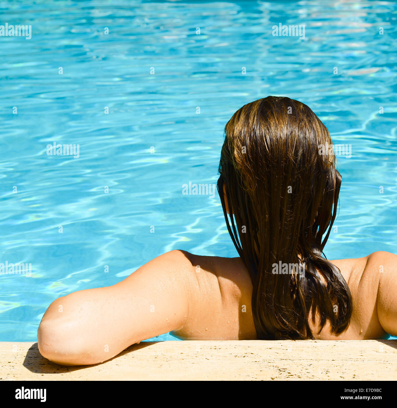 Back view of relaxed woman in swimming pool with blue water Stock Photo ...
