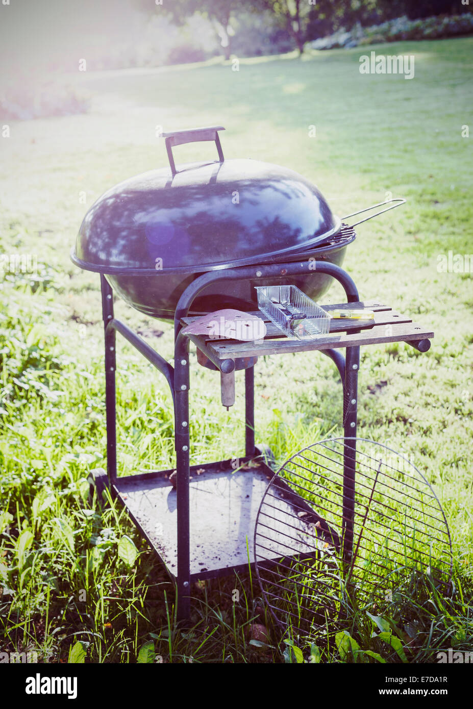 Vintage picture of old metal barbecue in the summer garden. Stock Photo