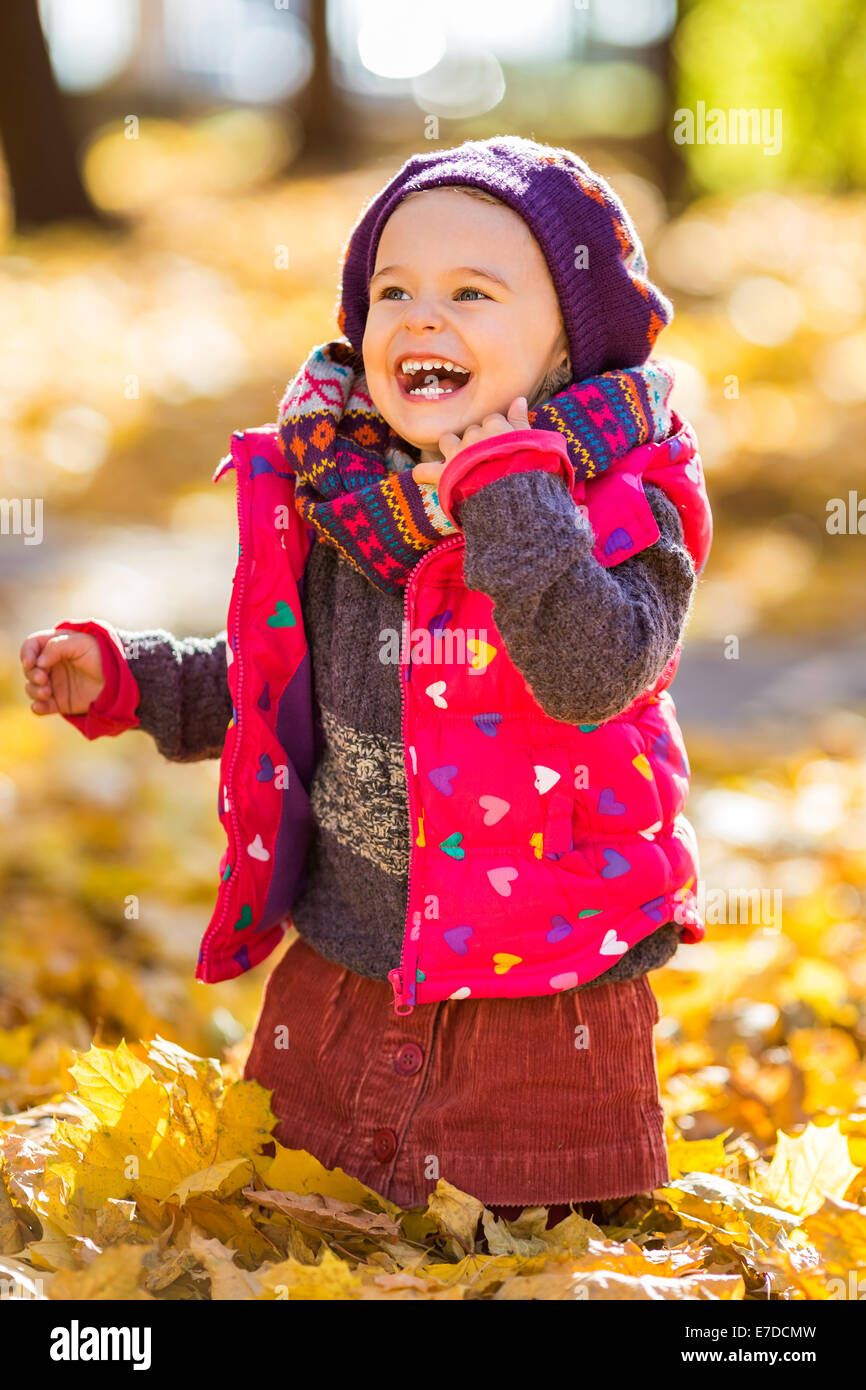 Happy little girl playing in the autumn park Stock Photo - Alamy