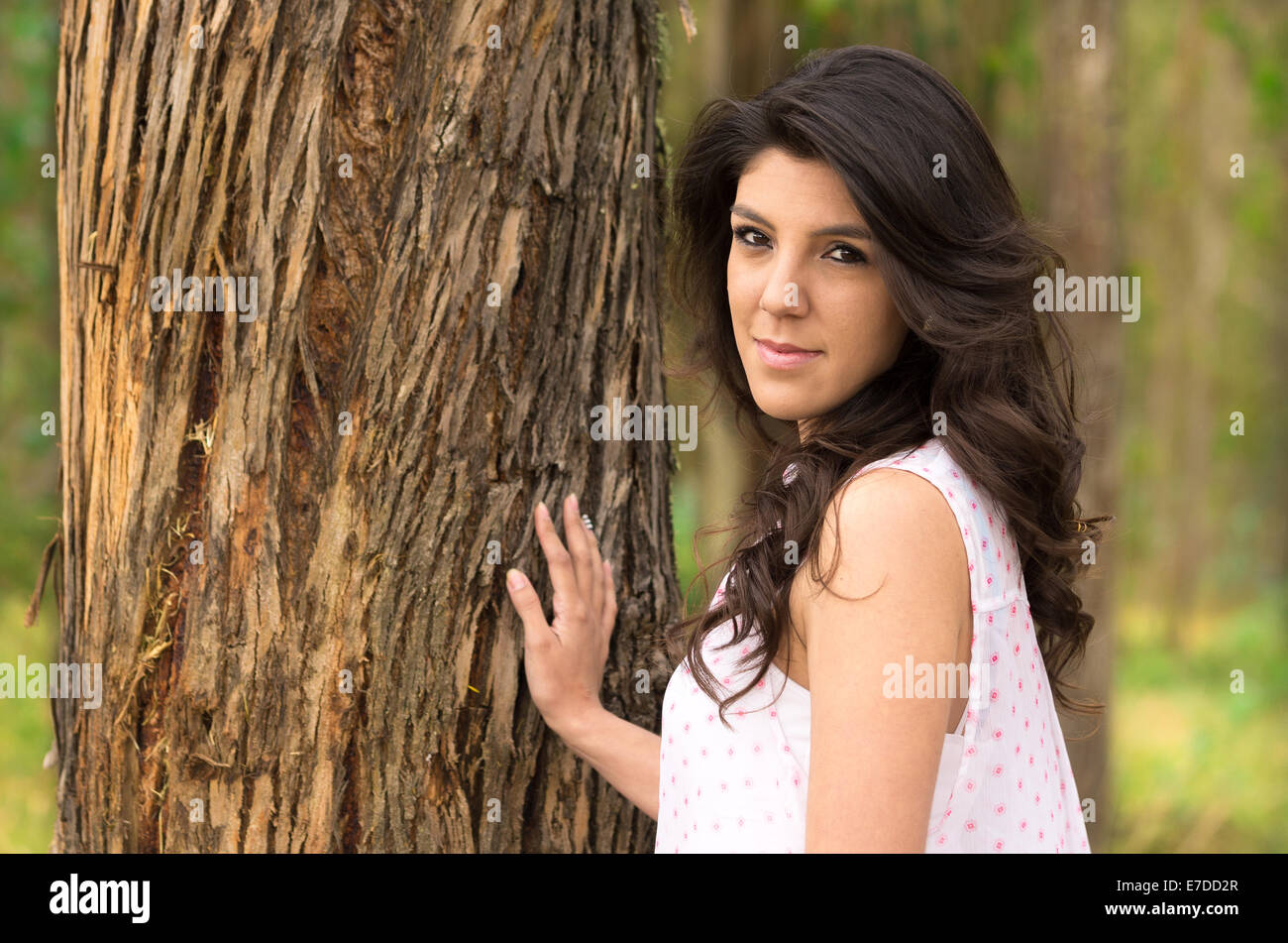 Gorgeous young girl posing besides a tree Stock Photo - Alamy