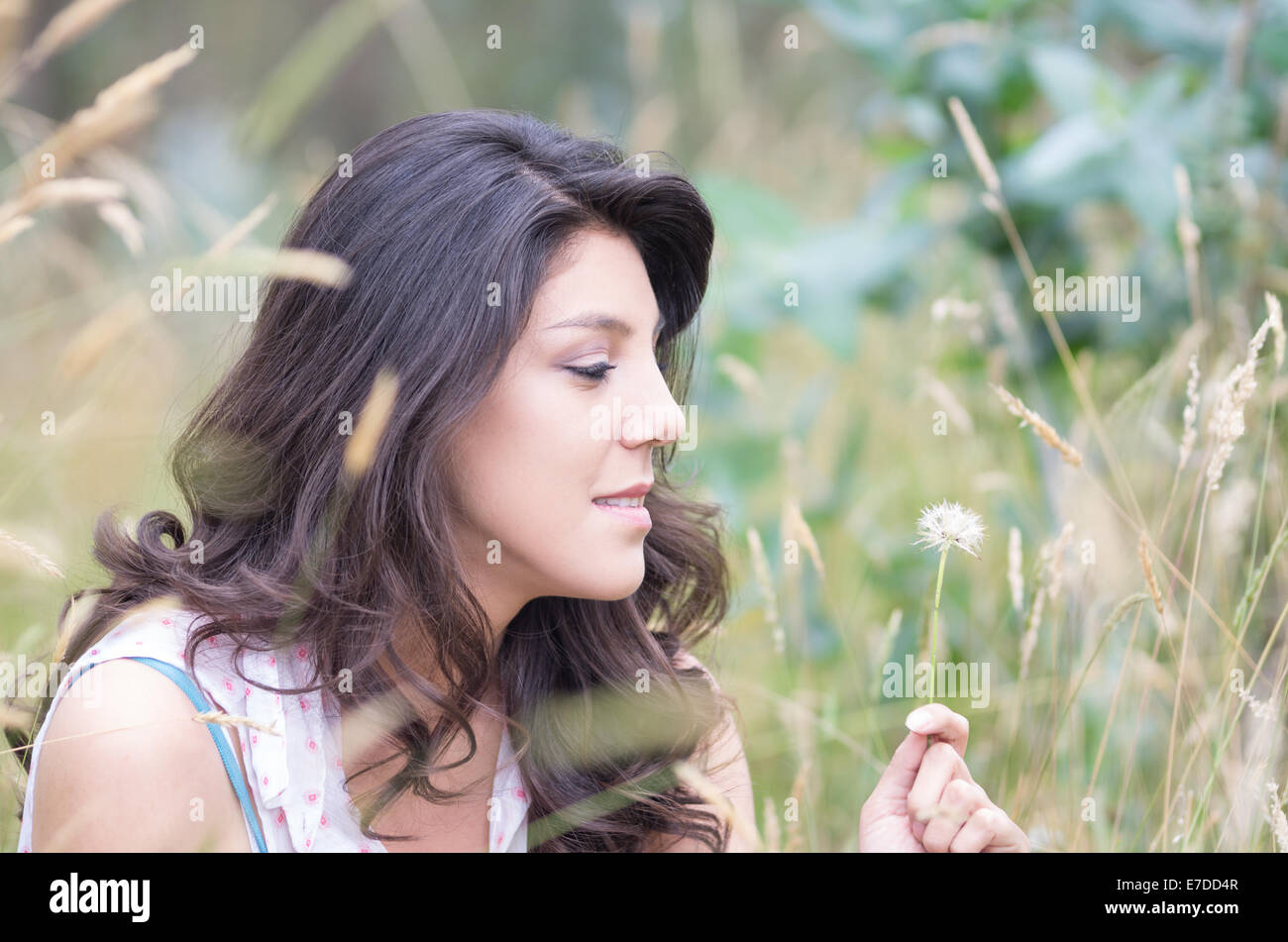 pretty young girl sitting in a field Stock Photo - Alamy