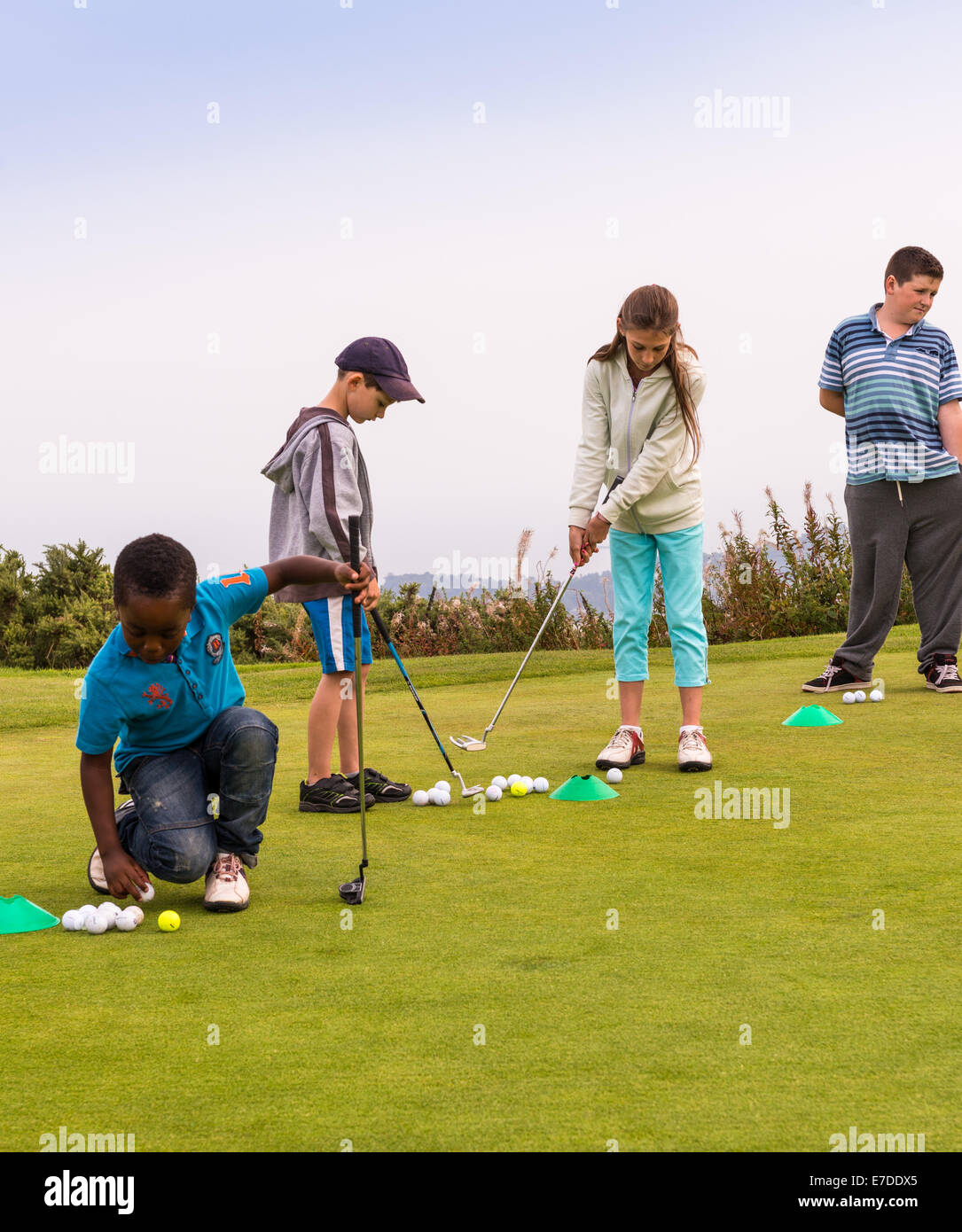Young junior golfers are having a putting lesson on the practice