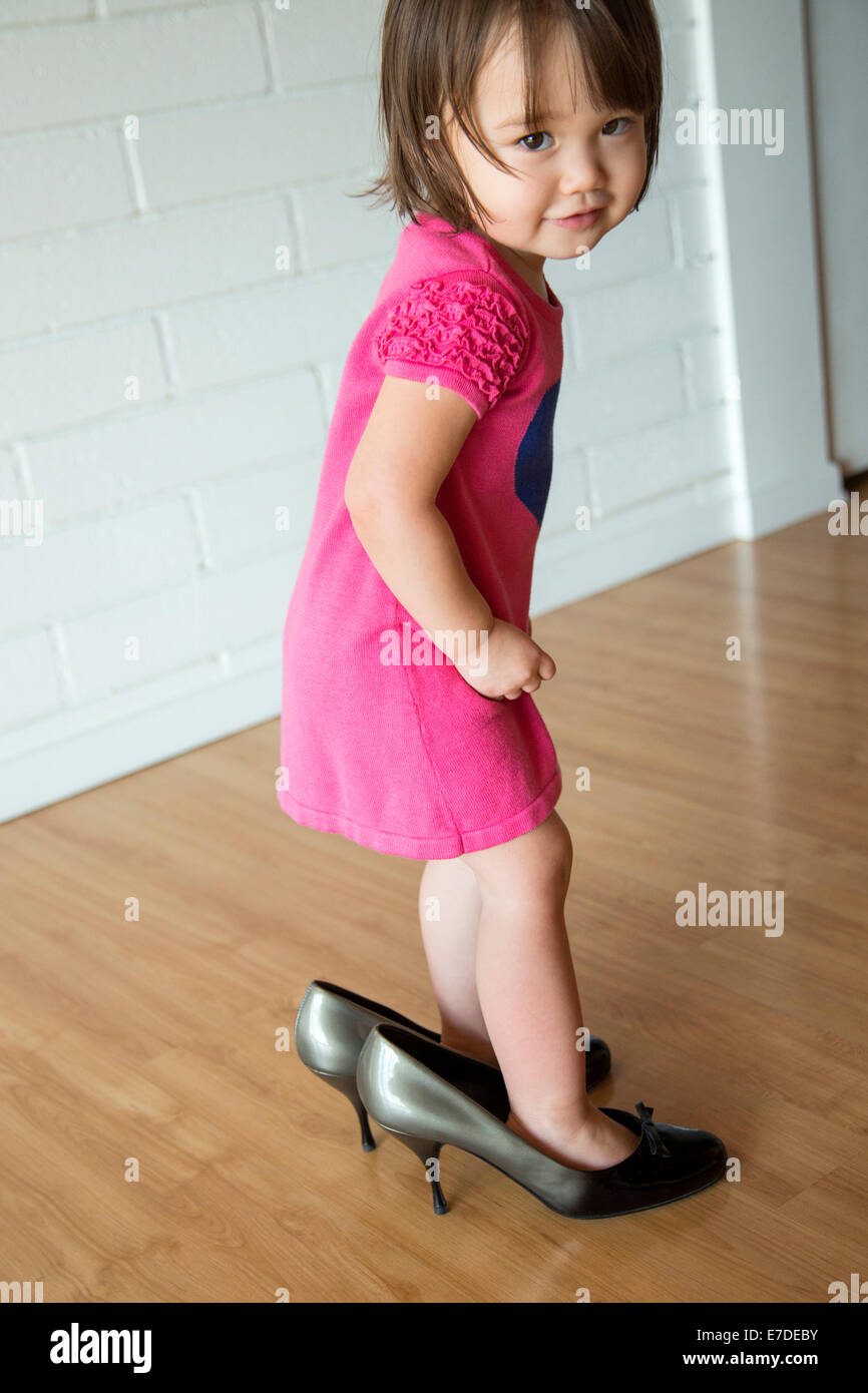 Baby girl in her mother's shoes Stock Photo