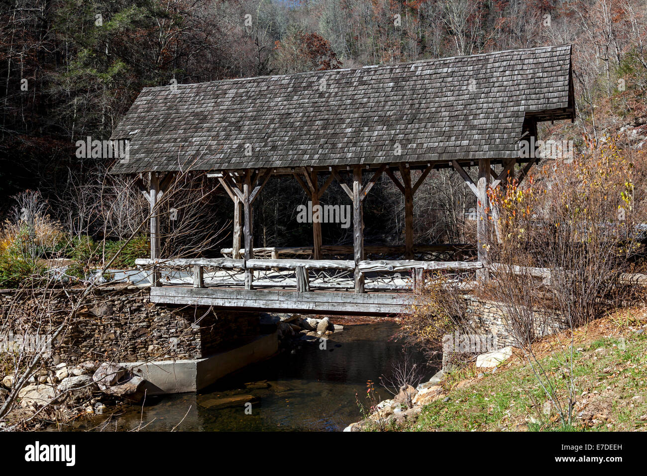 Rustic log and timber covered bridge leads to private development along west fork Tuckasegee River just south of Tuckasegee Lake Stock Photo