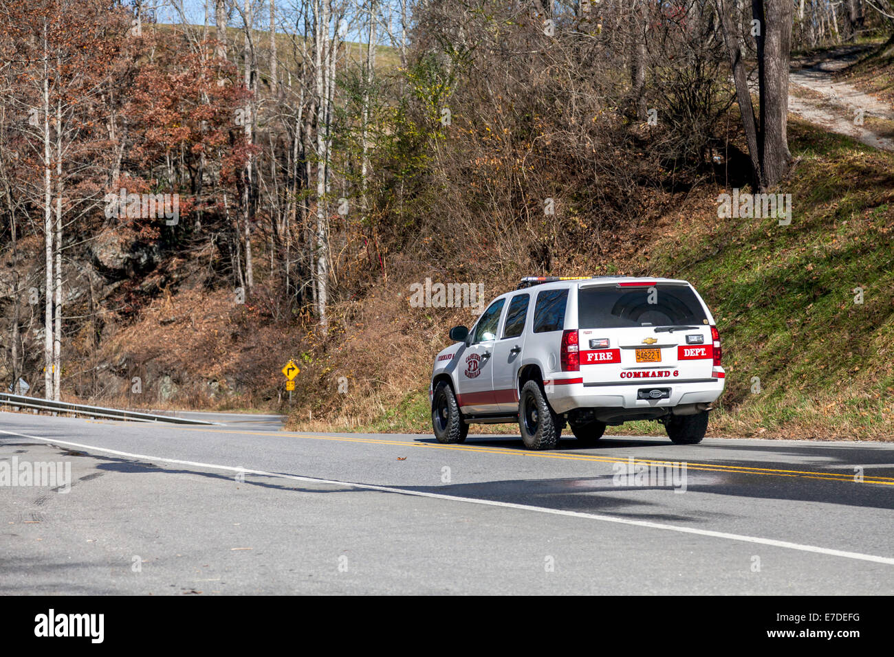 Emergency fire vehicle traveling on NC 107 along west fork Tuckasegee River just south of Tuckasegee Lake, North Carolina, USA. Stock Photo