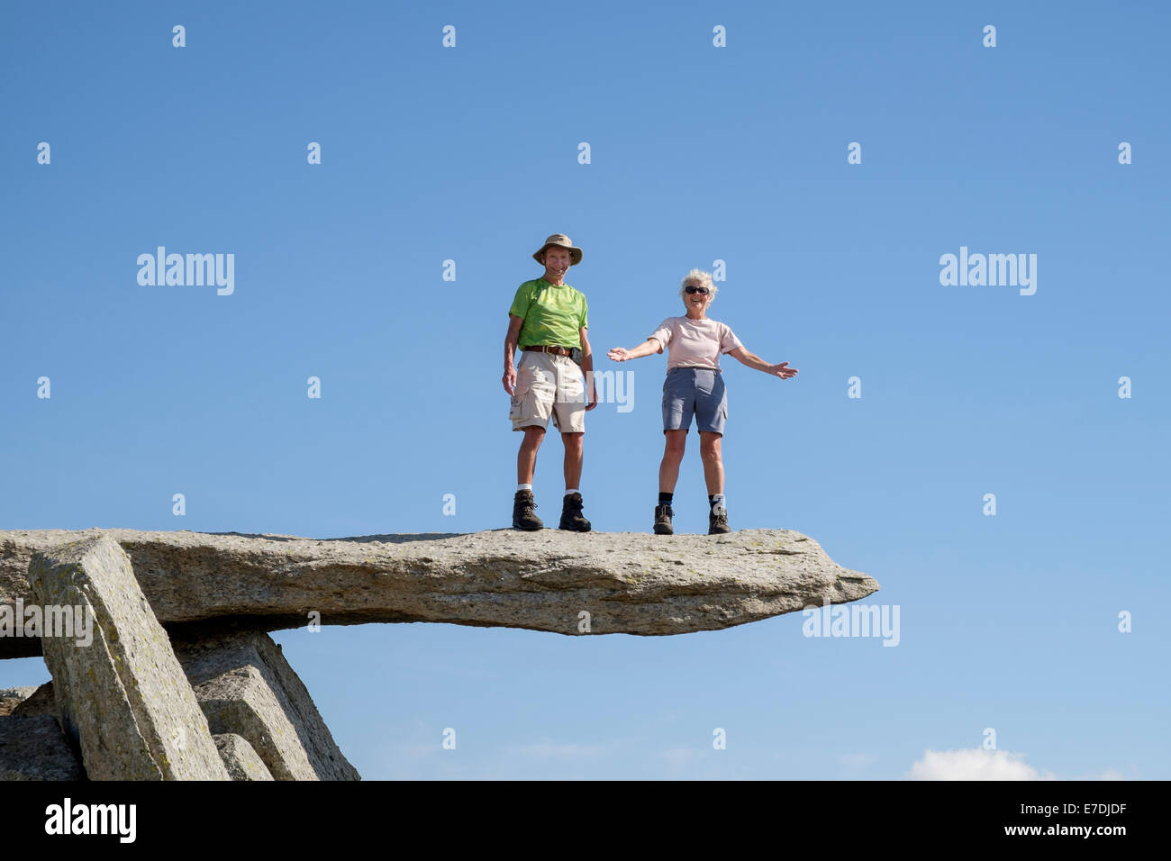 Two happy senior people with a sense of achievement living life to the full standing on cantilever rock on Glyder Fach in Snowdonia Wales UK Britain Stock Photo