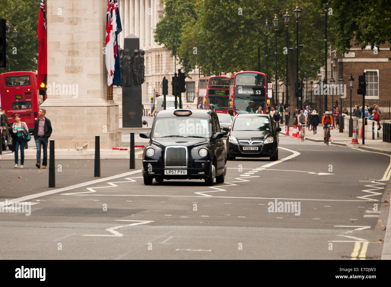 Black Taxis on London Street passing Cenotaph Stock Photo