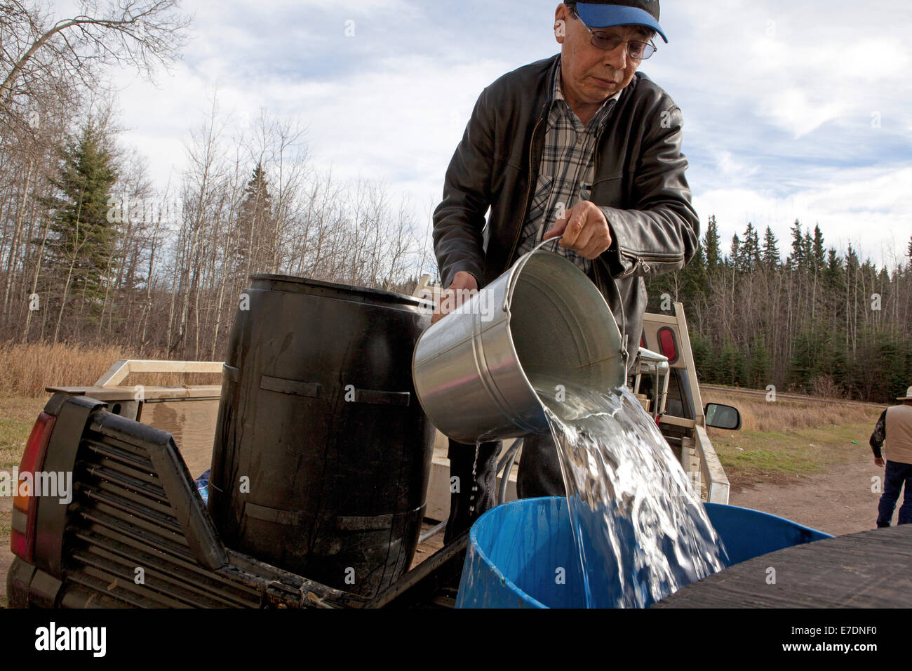 Man on pick up truck pouring fresh water from bucket, Peace River ...
