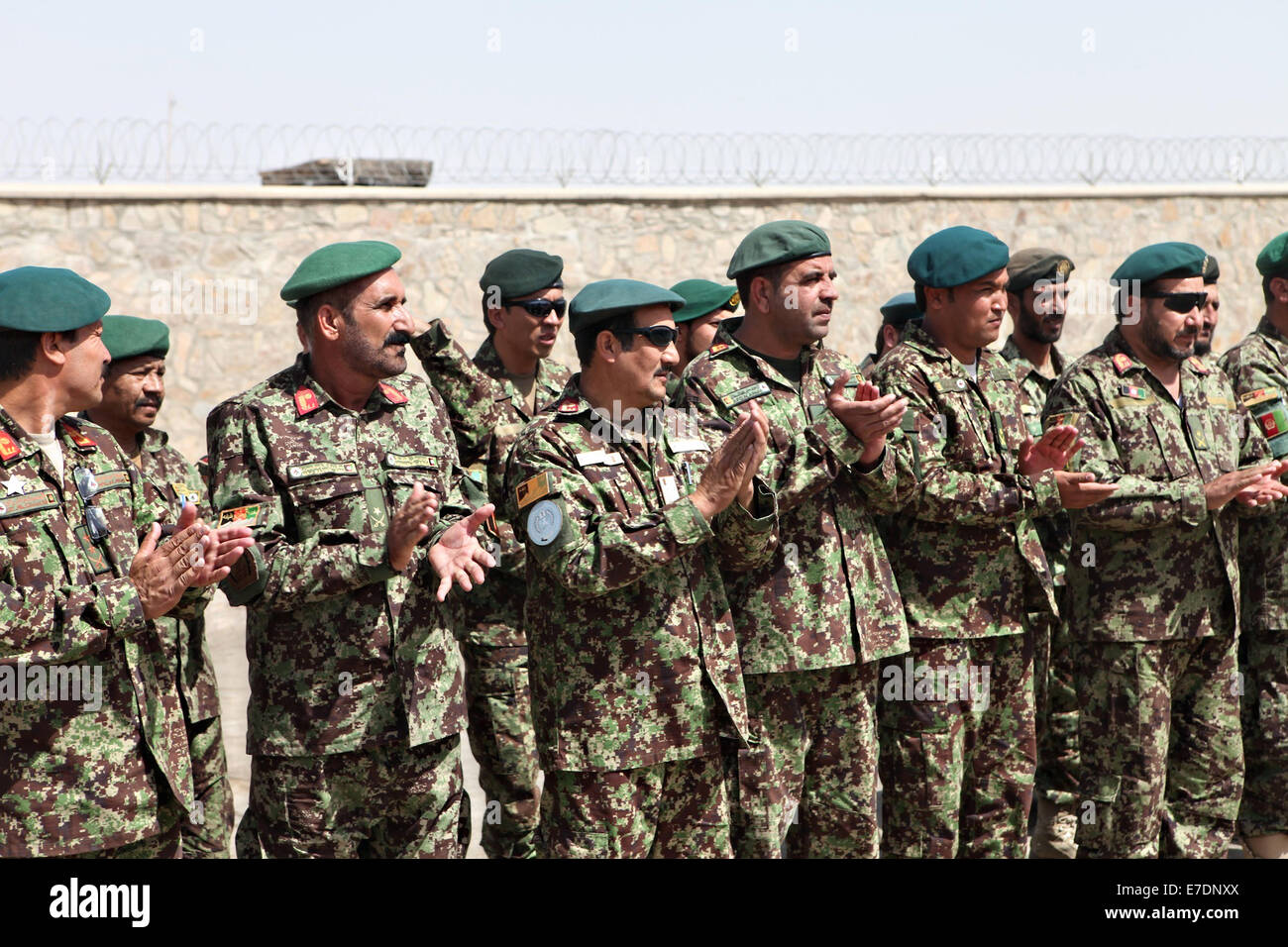 Afghan National Army soldiers with the 1st Brigade, 215th Corps, applaud at the ceremony for the newly constructed Camp Garm Ser September 1, 2014 in Garm Ser, Helmand province, Afghanistan. Stock Photo
