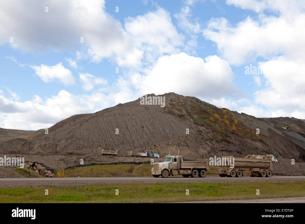 Truck on highway by oil sands slag heap, Fort McMurray, Alberta, Canada. Stock Photo