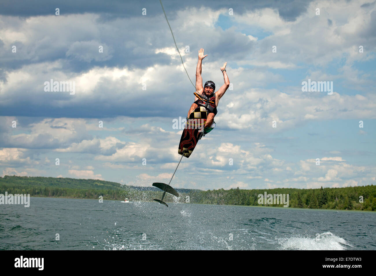 Man jumping mid air while wakeboarding on Crane Lake, Alberta, Canada Stock Photo