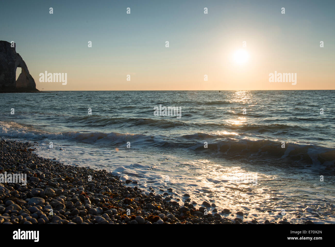 Sunset on the beach at Etratat on the coast of Normandy in Northern ...