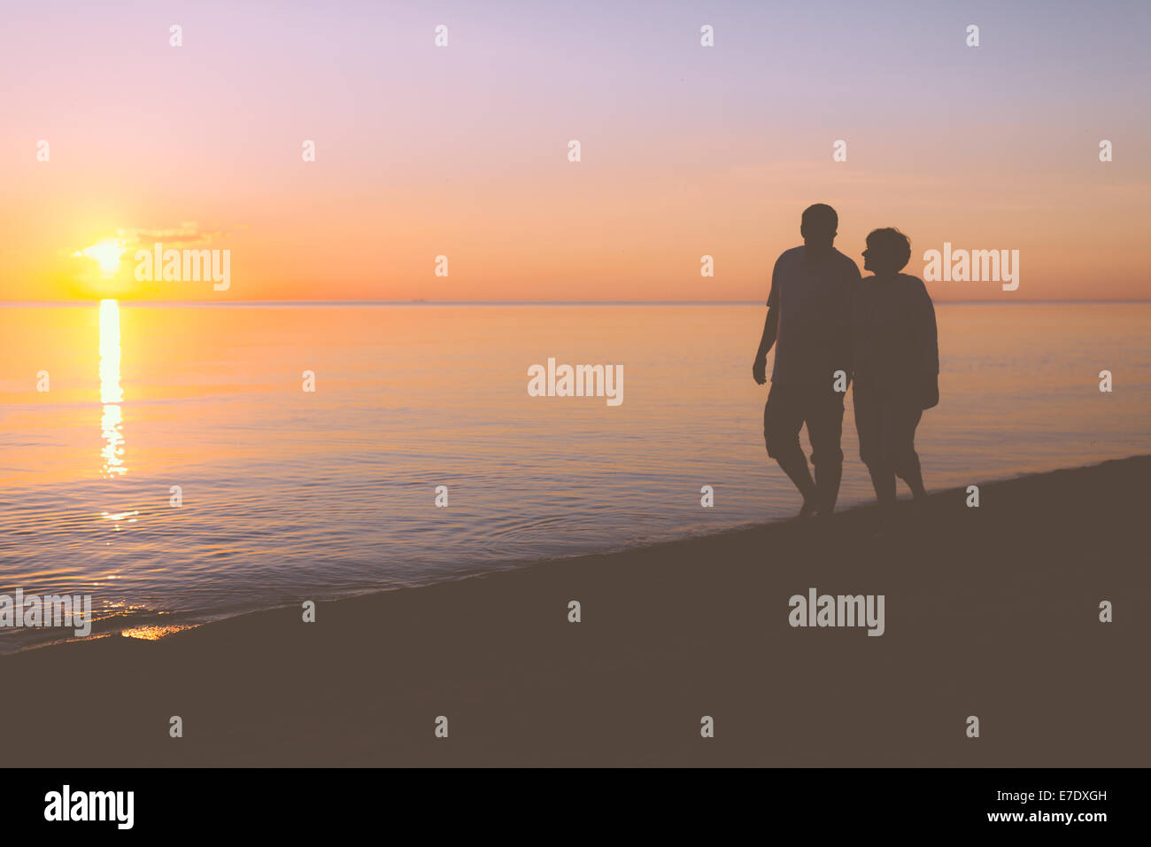 Old couple walking along beach hi-res stock photography and images - Alamy