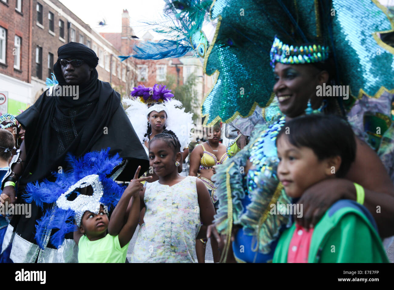 Participants pose for pictures dressed in fancy costumes, one as a Wester Sahara Tuareg while they dance down Mare Street Stock Photo