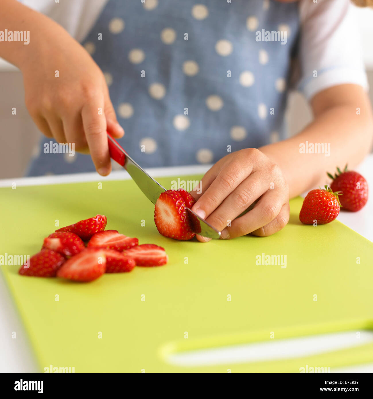 child slicing strawberries Stock Photo
