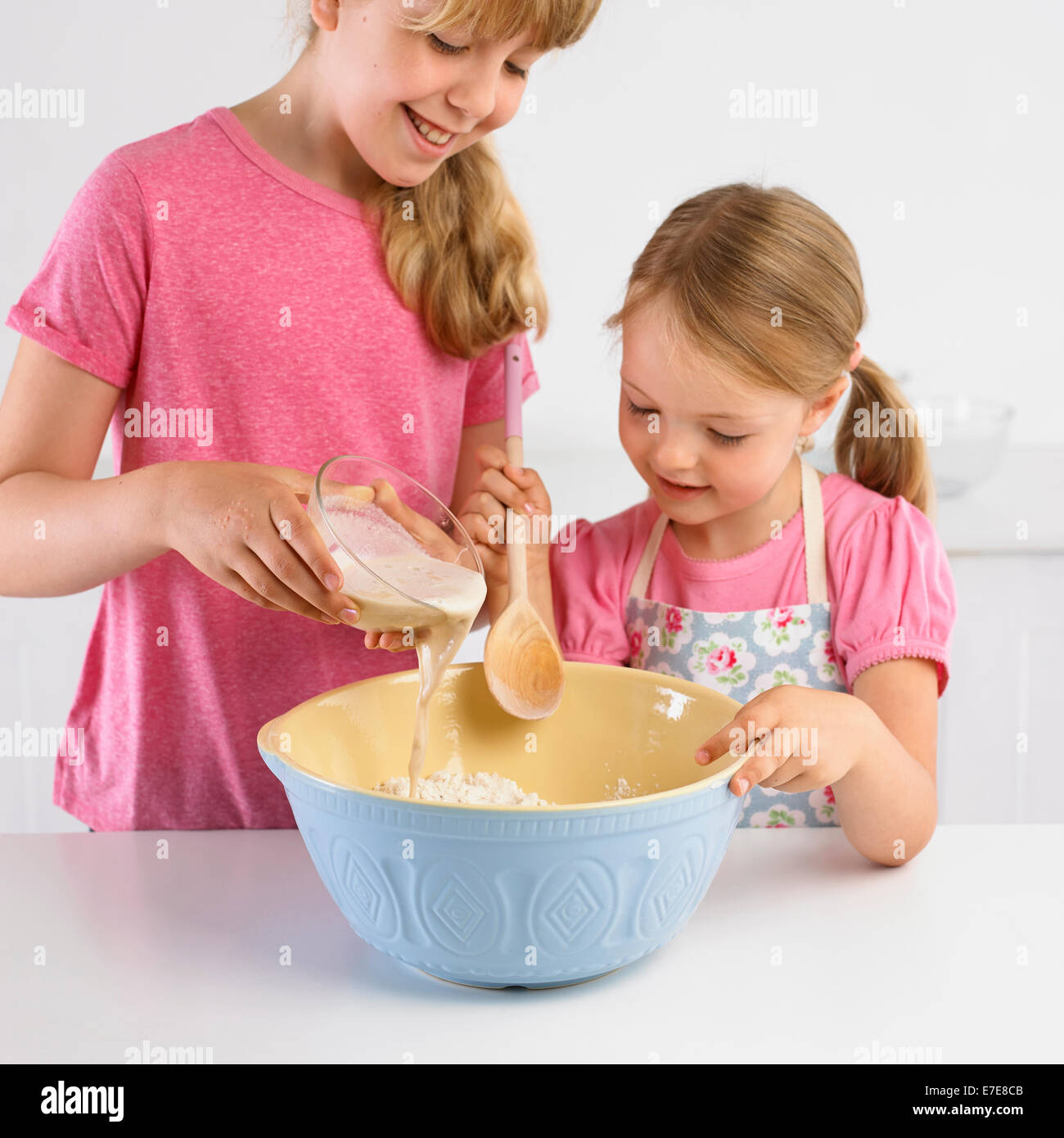 Pouring yeast and water into flour, making bread Stock Photo Alamy