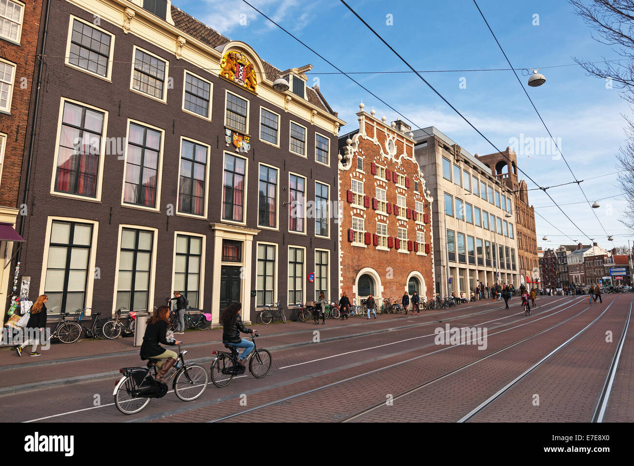 AMSTERDAM, NETHERLANDS - MARCH 19, 2014: Streetview with colorful brick houses. Ordinary people are on the street Stock Photo