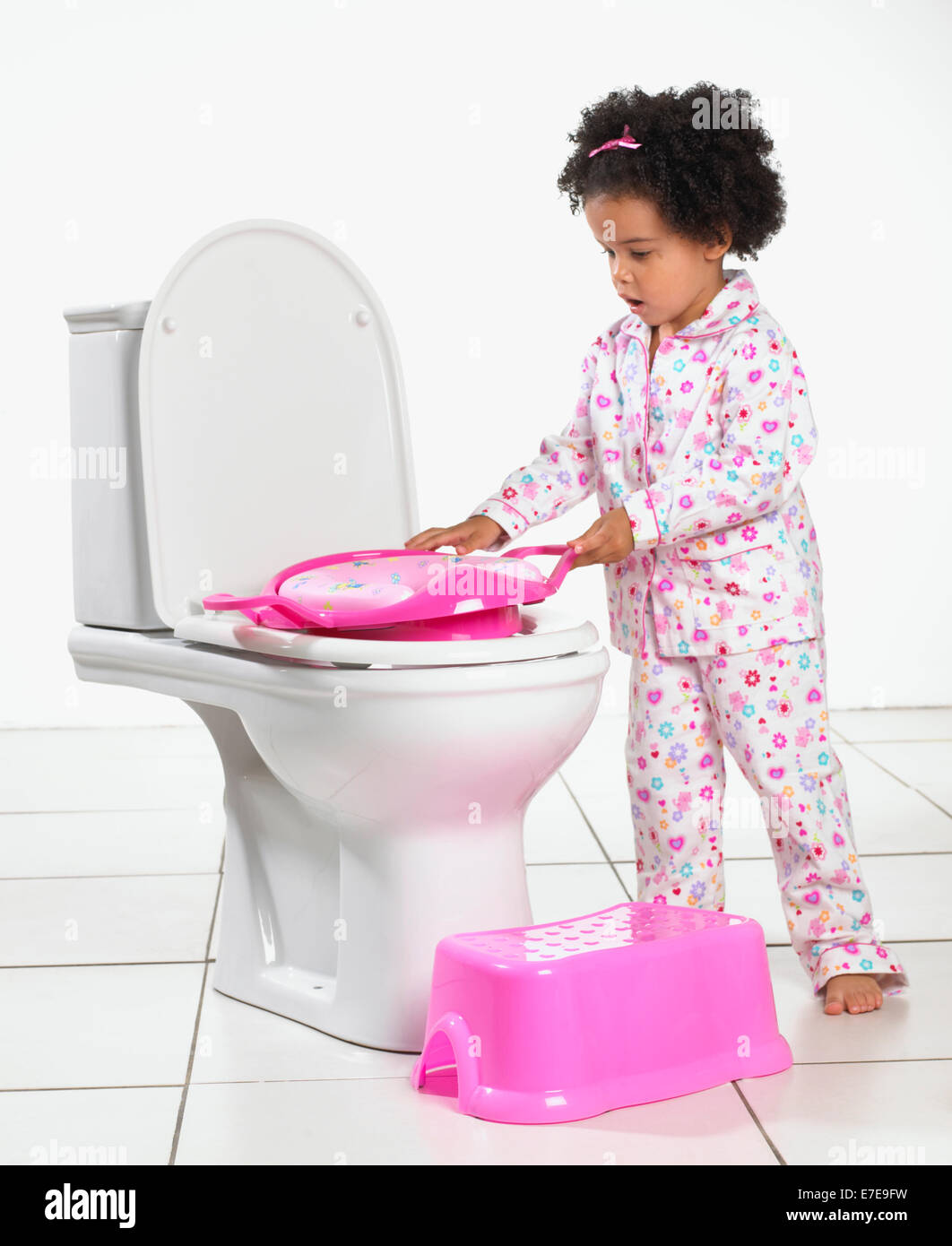 Girl putting toilet seat for toddlers onto tolilet Stock Photo Alamy