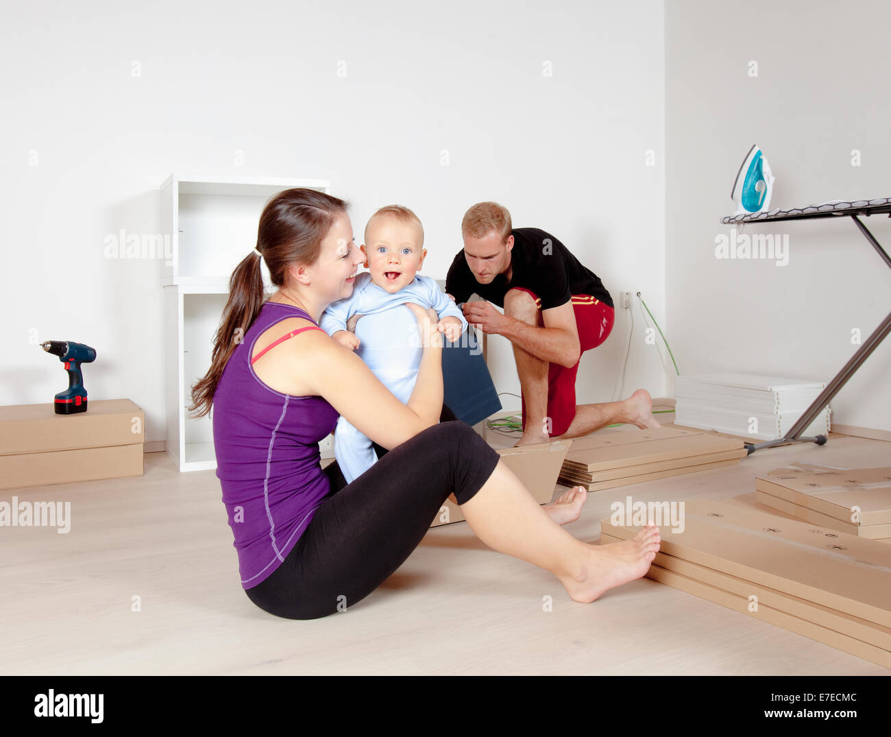 Young Family with a Baby  Moving in a New Apartment Stock Photo