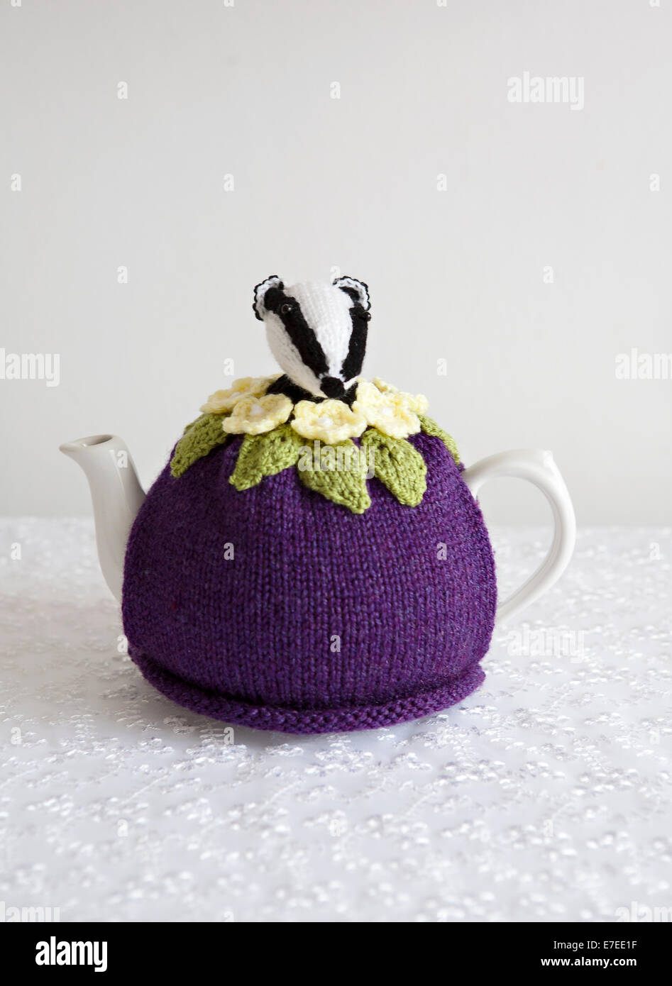 Vintage style knitted Tea Cosy with Badger on a bed of Primroses Stock Photo