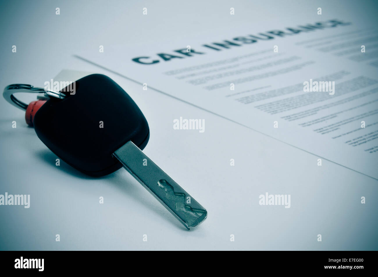 closeup of a car key and a car insurance policy Stock Photo