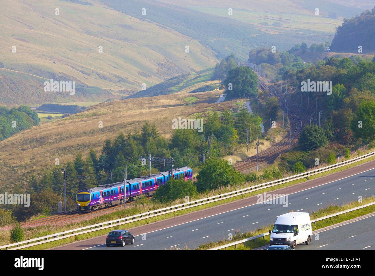 First Group Trans Pennine Express, Class 185 train passing the M6 motorway in the River Lune Valley. Howgills, Cumbria, UK. Stock Photo