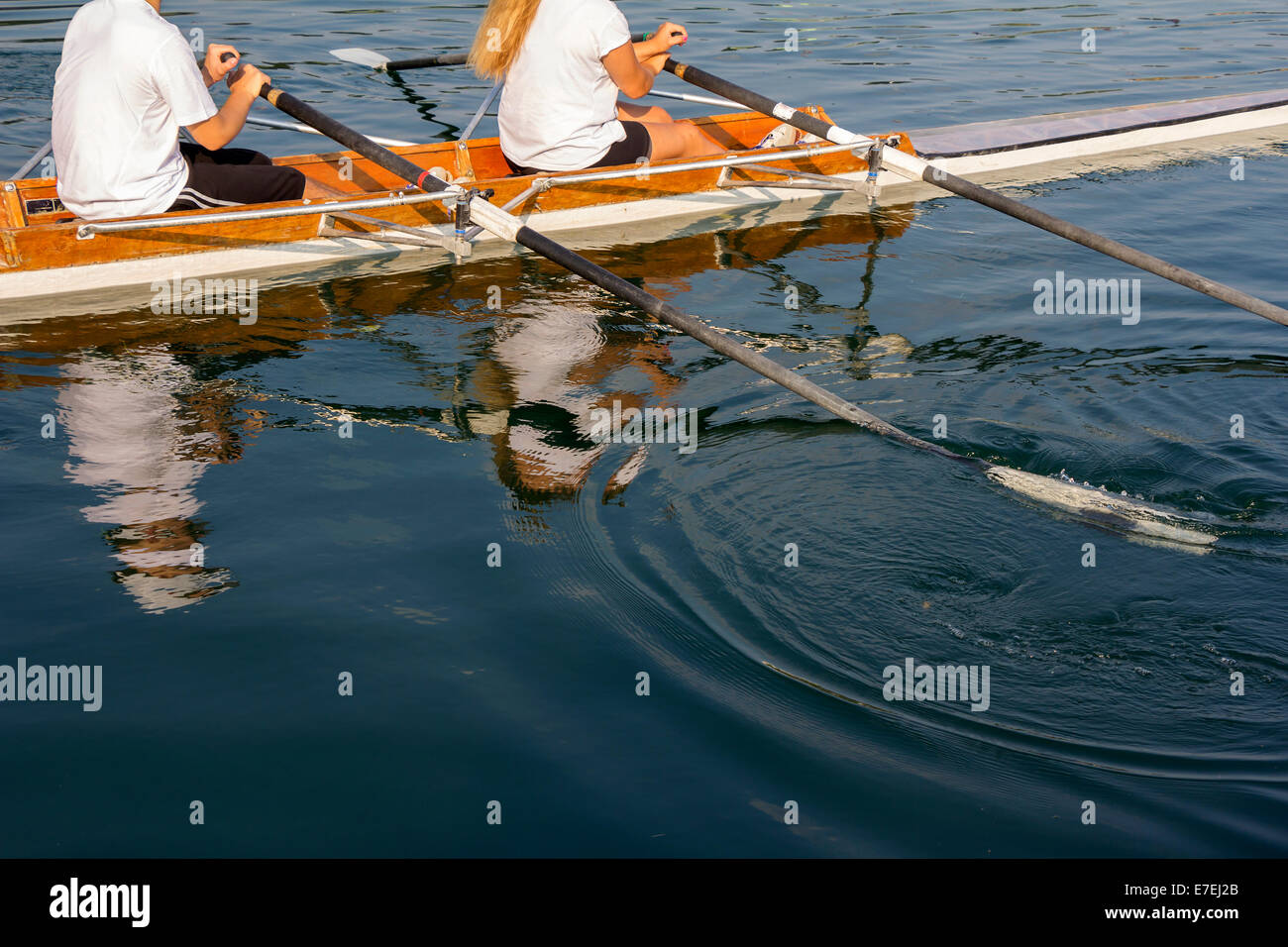 Man and woman in a boat, paddles on the tranquil lake Stock Photo - Alamy