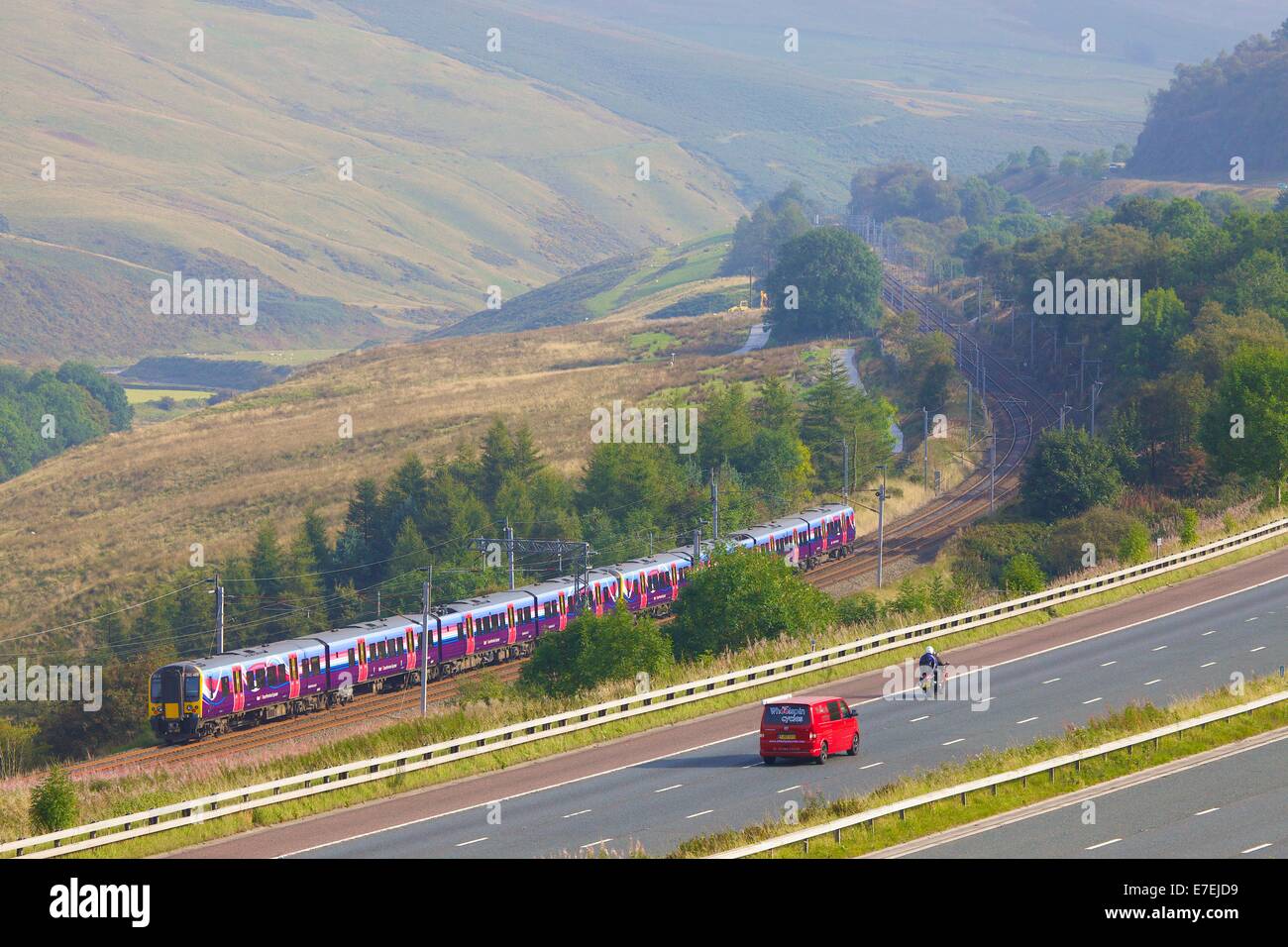 First Group Trans Pennine Express, Class 185 train passing the M6 motorway in the River Lune Valley. Howgills, Cumbria, UK. Stock Photo