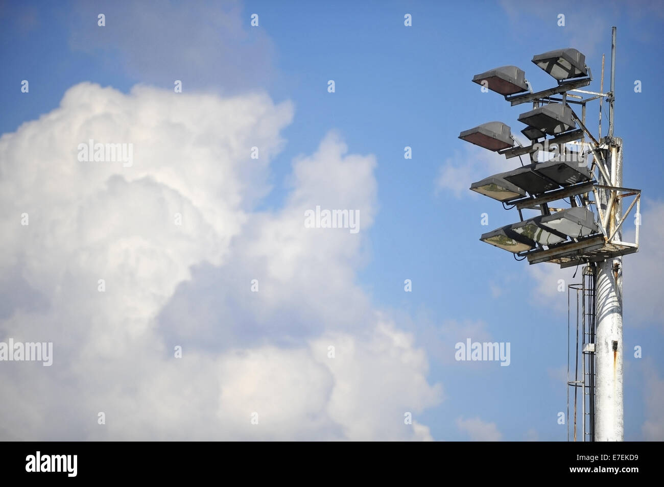 Sports arena floodlights during daytime with clouds on the background Stock Photo