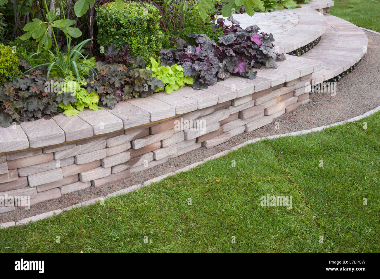 Garden - Bacchus Garden - view of garden with stone wall raised bed steps grass lawn planting of Heuchera and b Stock Photo