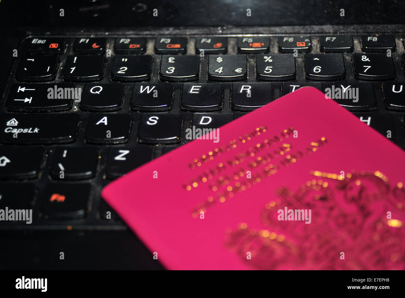 Image of a 2010 British passport photographed against a computer keyboard Stock Photo