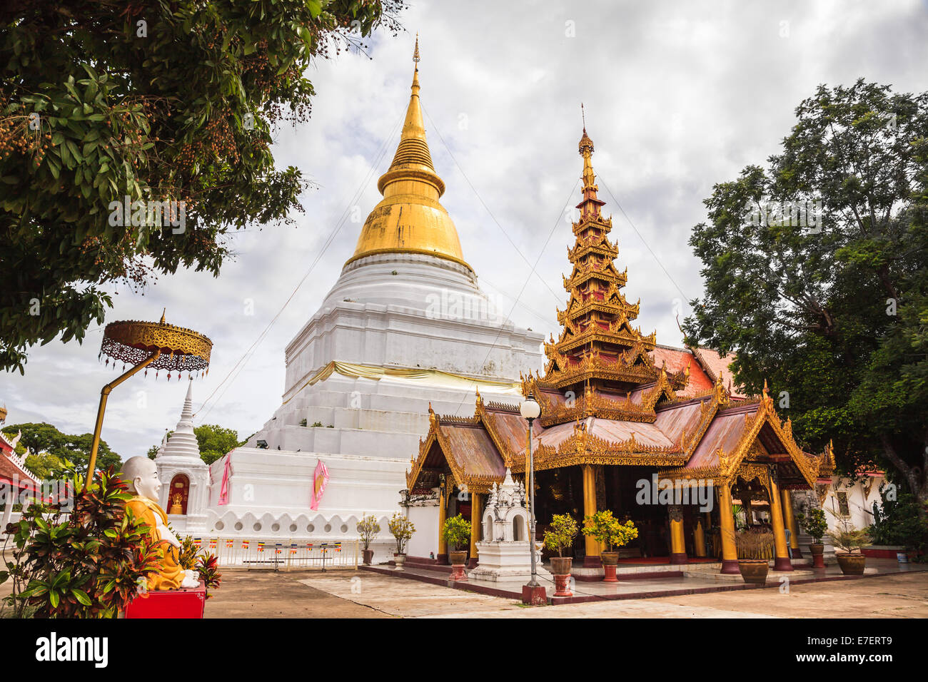 Ancient golden pagoda and myanmar style viharn at buddhist temple in lampang province, thailand Stock Photo