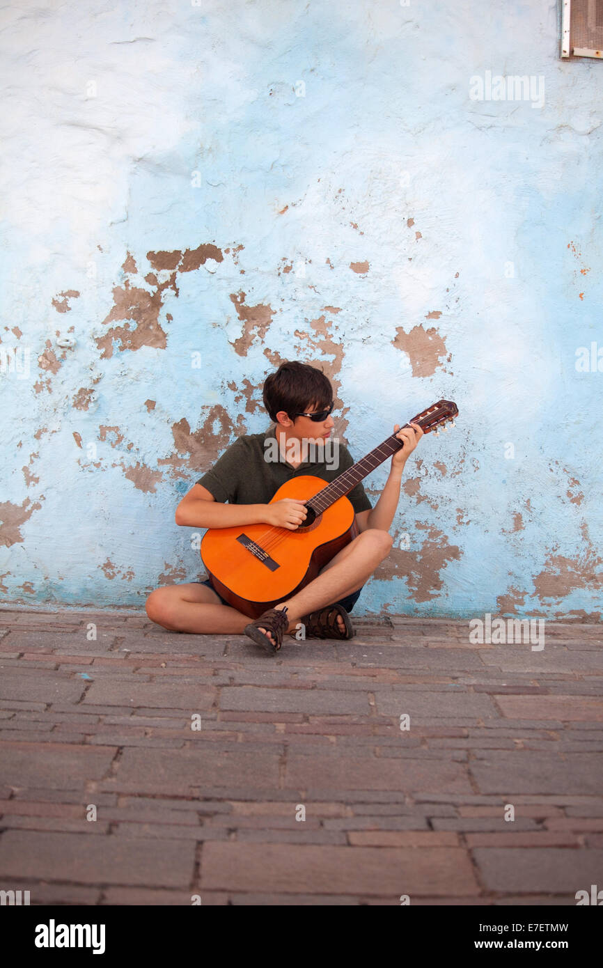 teenager busking playing acoustic guitar Stock Photo