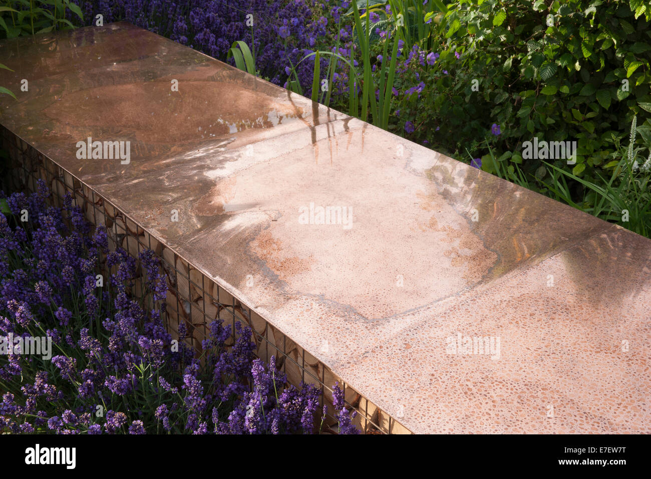 Garden - Vestra Wealth's Vista - view of garden bench made from copper with log pile for wildlife insect habita Stock Photo