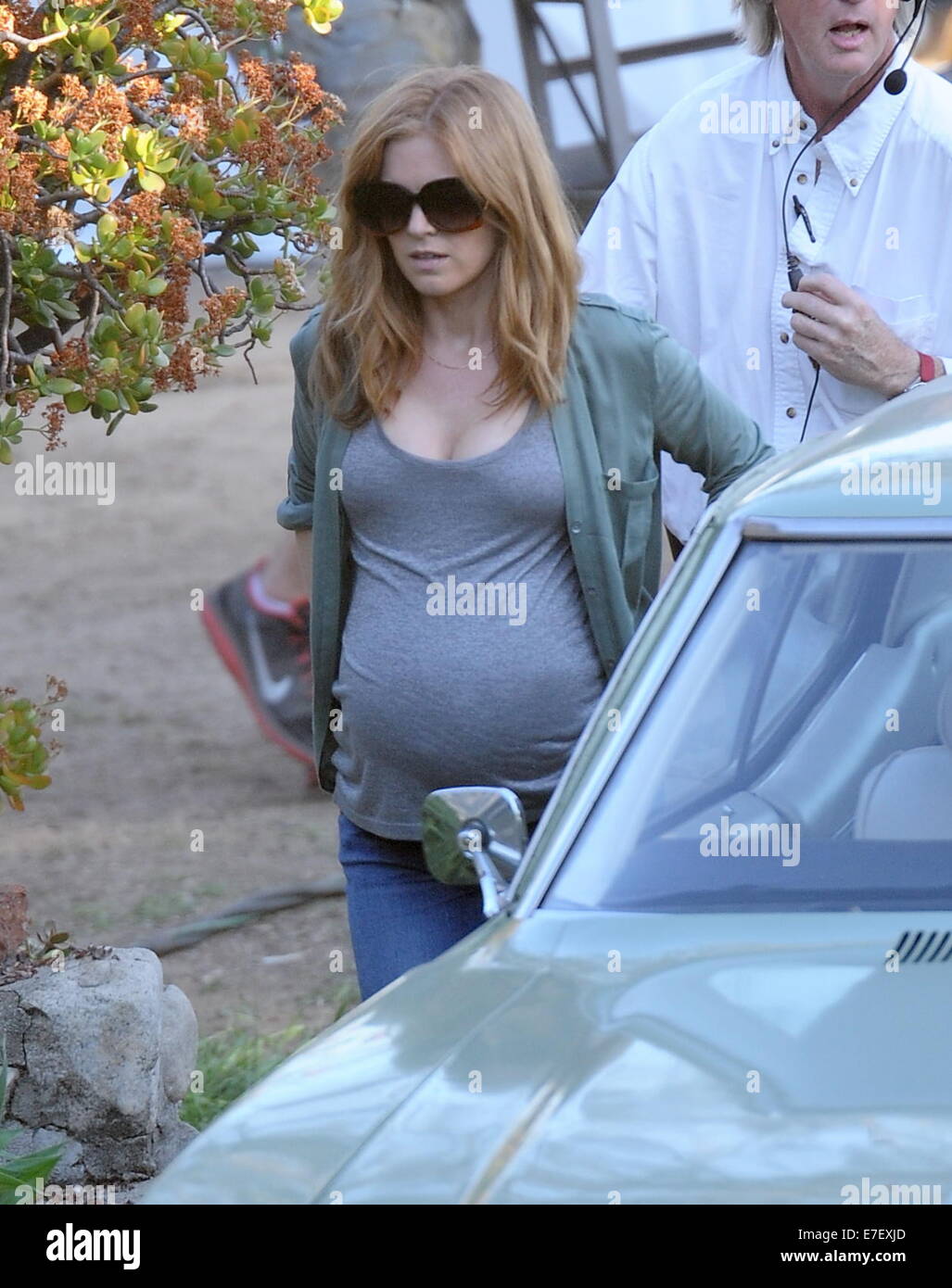 Isla Fisher shows off her huge pregnant belly bump while on the set of her new movie 'Visions' filming in Highland Park Ca. The actress seemed to be having a hard time getting into to her classic car for a scene with her huge prosthetic belly.  Featuring: Isla Fisher Where: Highland Park, California, United States When: 13 Mar 2014 Stock Photo