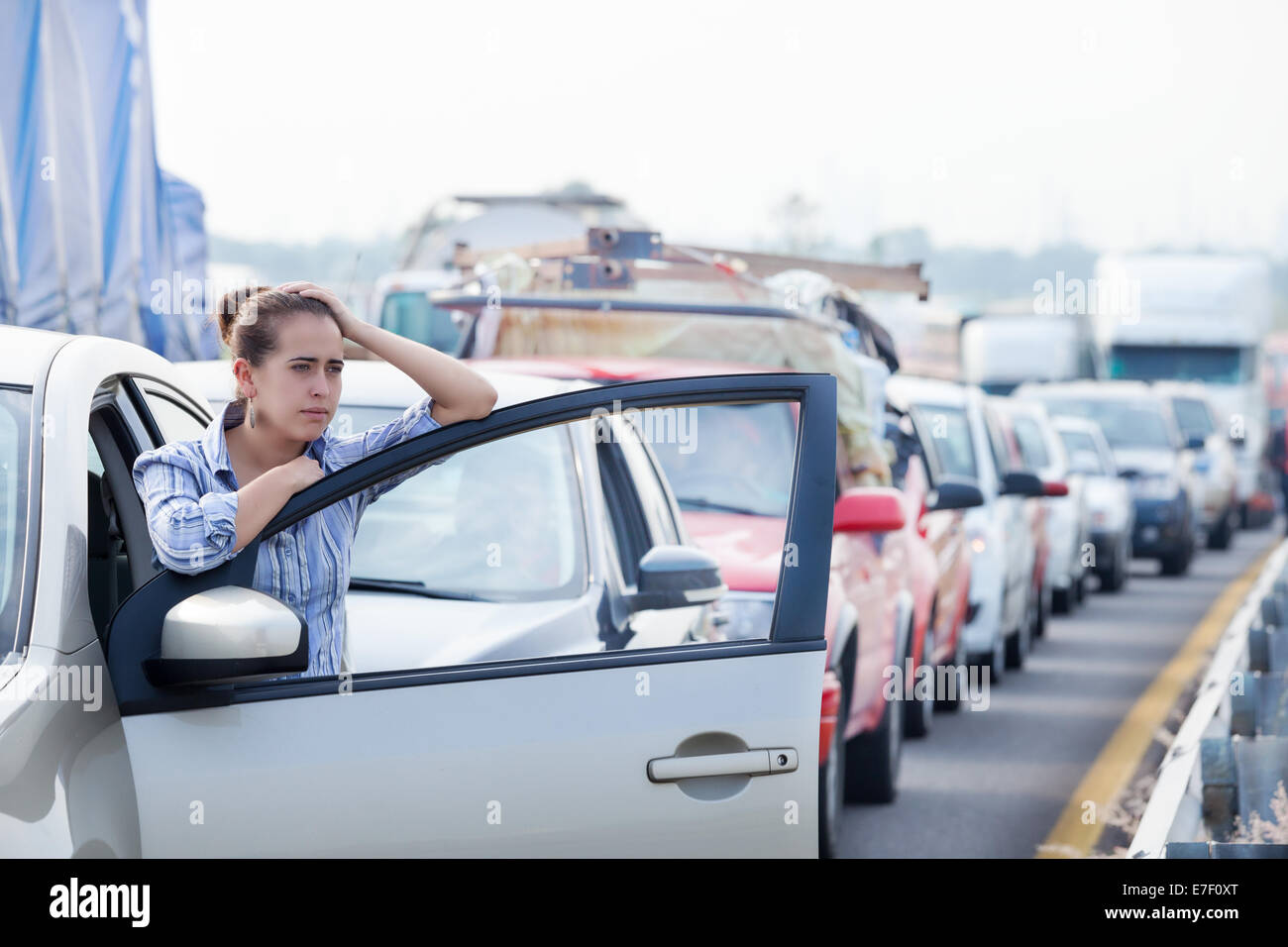 Frustrated young Hispanic woman stuck in a traffic jam. Stock Photo