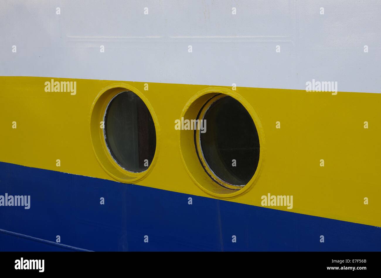 two portholes of ship on background of yellow board Stock Photo