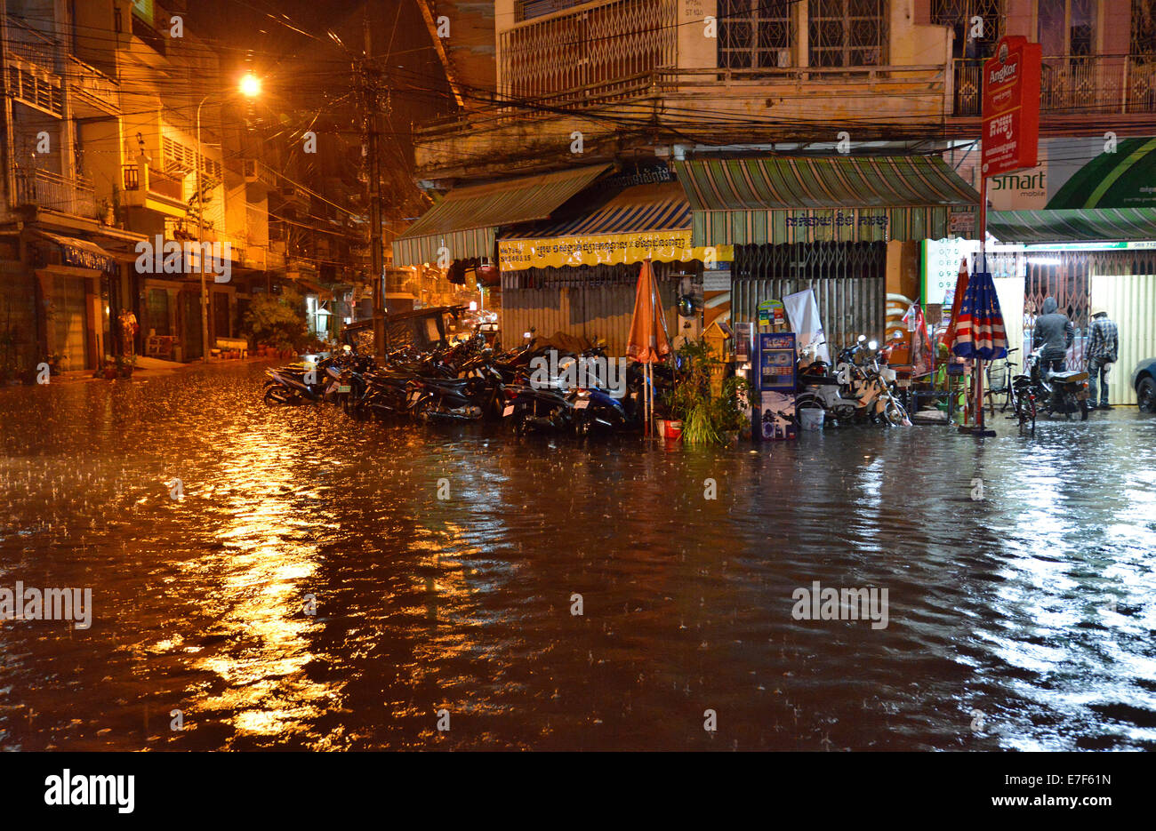 Street scene with a flooded road during heavy monsoon rain at night, city centre, Phnom Penh, Cambodia Stock Photo