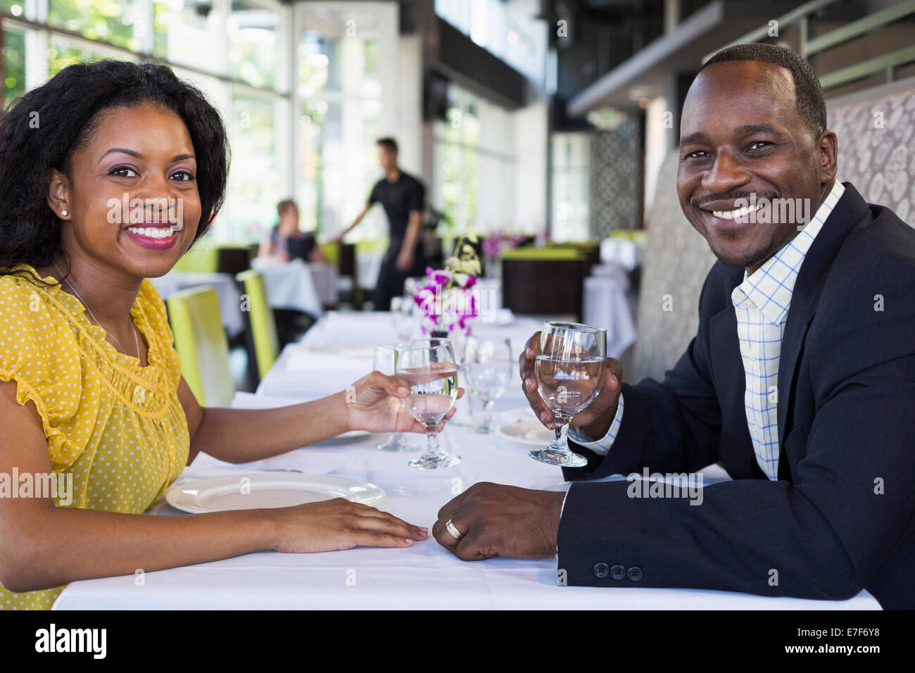 African American couple smiling in restaurant Stock Photo