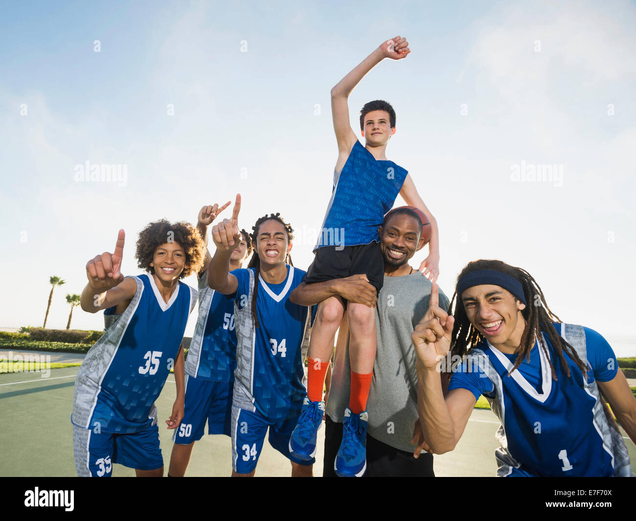 Basketball team cheering on court Stock Photo Alamy
