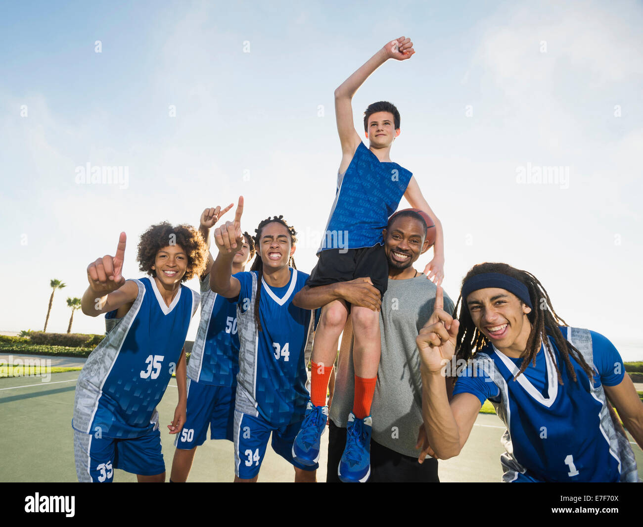Basketball team cheering on court Stock Photo