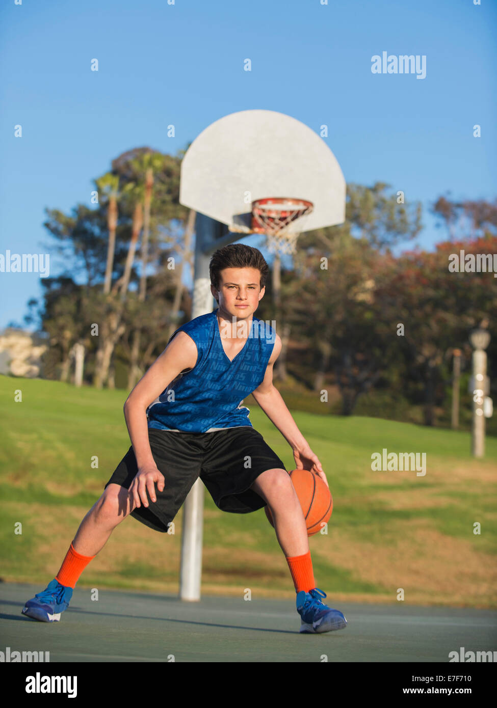 Caucasian basketball player dribbling ball on court Stock Photo